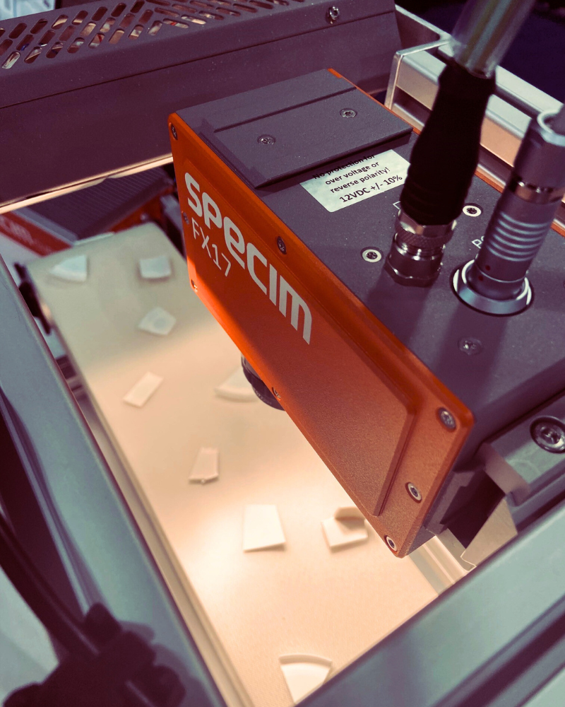 Specim FX17 camera mounted over conveyor with plastic pieces moving underneath